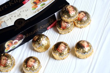 KHARKOV, UKRAINE - 19 Nisan 2021: Henry Lambertz Mozart-Kugeln lüks siyah çikolata şekerlemeleri beyaz ahşap masa üzerindeki kara kutuda