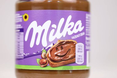 KHARKOV, UKRAINE - 2 Temmuz 2021: Beyaz ahşap masa üzerinde klasik leylak rengi tasarımı ile yayılmış Milka tatlandırılmış fındık kakaosu kutusu