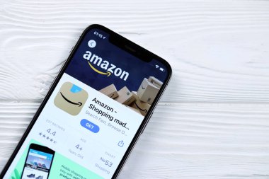 KHARKOV, UKRAINE - 5 Mart 2021: Amazon simgesi ve uygulaması iPhone 12 'den beyaz ahşap masadaki profesyonel ekranda