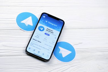 KHARKOV, UKRAINE - 5 Mart 2021: Telegram Messenger simgesi ve uygulaması iPhone 12 'de beyaz ahşap masadaki profesyonel ekranda