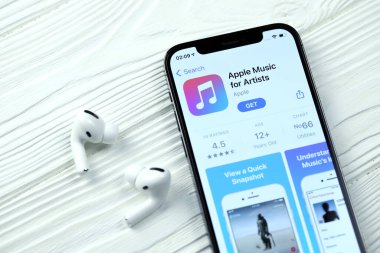 KHARKOV, UKRAINE - 5 Mart 2021: Sanatçı simgesi ve uygulaması için Apple müziği iPhone 12 profesyonel ekranda beyaz ahşap masa uzmanıyla birlikte