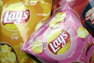 KHARKOV, UKRAINE - 3 HAZİRAN 2021: Ahşap zemin üzerinde lay 's patates cipsi çeşitli aromalı. Lay 's 1965' ten beri PepsiCo tarafından Frito-Lay 'e ait.