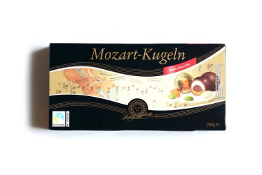 KHARKOV, UKRAINE - 19 Nisan 2021: Henry Lambertz Mozart-Kugeln lüks siyah çikolata şekerlemeleri beyaz ahşap masa üzerindeki kara kutuda