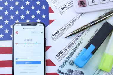 KHARKOV, UKRAINE - 5 Mart 2021: Turbotax sezgi web sitesi iPhone 12 profesyonel ekranda 1040 ve w-2 ABD bayrağında kağıt vergi formları