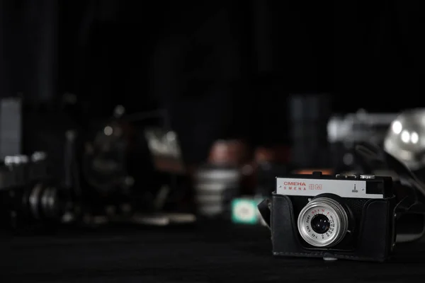 Kharkov Ukraine エイプリル27 2021 Smena 8Mフィルムフォトカメラと写真家の暗室にある黒い木製のテーブルの上にあるもう一つの古いレトロなフォト機器 ソ連時代の写真装置 — ストック写真