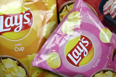 KHARKOV, UKRAINE - 3 HAZİRAN 2021: Ahşap zemin üzerinde lay 's patates cipsi çeşitli aromalı. Lay 's 1965' ten beri PepsiCo tarafından Frito-Lay 'e ait.