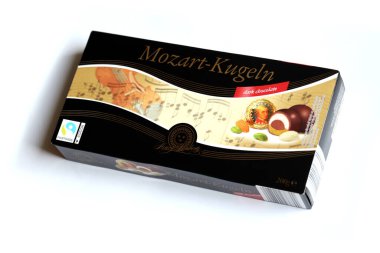 KHARKOV, UKRAINE - 19 Nisan 2021: Henry Lambertz Mozart-Kugeln lüks siyah çikolata şekerlemeleri beyaz ahşap masa üzerindeki kara kutuda
