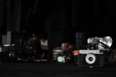 KHARKOV, UKRAINE - 27 Nisan 2021: Smena 8 metre fotoğraf makinesi ve fotoğrafçı karanlık odasındaki siyah ahşap masada eski bir fotoğraf makinesi. Sovyetler Birliği zamanından fotoğraf malzemeleri.