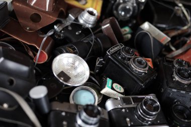 KHARKOV, UKRAINE - 27 Nisan 2021: Fotoğraf makineleri ve fotoğrafçı karanlık odasındaki siyah ahşap masada eski bir fotoğraf makinesi. Sovyetler Birliği zamanından fotoğraf malzemeleri.