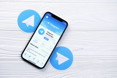 KHARKOV, UKRAINE - 5 Mart 2021: Telegram Messenger simgesi ve uygulaması iPhone 12 'de beyaz ahşap masadaki profesyonel ekranda