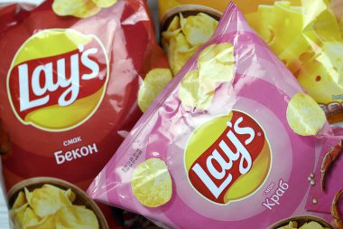 KHARKOV, UKRAINE - 3 HAZİRAN 2021: Ahşap zemin üzerinde lay 's patates cipsi çeşitli aromalı. Lay 's 1965' ten beri PepsiCo tarafından Frito-Lay 'e ait.