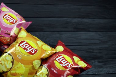 KHARKOV, UKRAINE - 3 HAZİRAN 2021: Ahşap zemin üzerinde lay 's patates cipsi çeşitli aromalı. Lay 's 1965' ten beri PepsiCo tarafından Frito-Lay 'e ait.