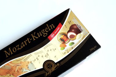 KHARKOV, UKRAINE - 19 Nisan 2021: Henry Lambertz Mozart-Kugeln lüks siyah çikolata şekerlemeleri beyaz ahşap masa üzerindeki kara kutuda