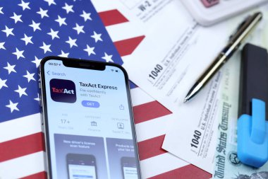 KHARKOV, UKRAINE - 5 Mart 2021: Vergilendirme ekspres uygulaması iPhone 12 profesyonel ekranda 1040 ve W-2 ABD bayrağında kağıt vergisi formları