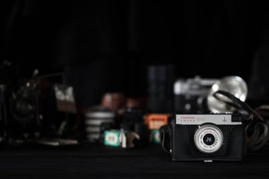 KHARKOV, UKRAINE - 27 Nisan 2021: Smena 8 metre fotoğraf makinesi ve fotoğrafçı karanlık odasındaki siyah ahşap masada eski bir fotoğraf makinesi. Sovyetler Birliği zamanından fotoğraf malzemeleri.