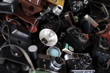 KHARKOV, UKRAINE - 27 Nisan 2021: Fotoğraf makineleri ve fotoğrafçı karanlık odasındaki siyah ahşap masada eski bir fotoğraf makinesi. Sovyetler Birliği zamanından fotoğraf malzemeleri.
