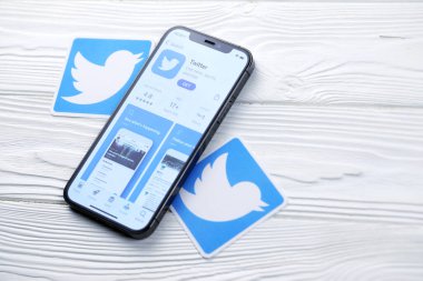 KHARKOV, UKRAINE - 5 Mart 2021: Twitter simgesi ve uygulaması iPhone 12 'den beyaz ahşap masadaki profesyonel ekranda