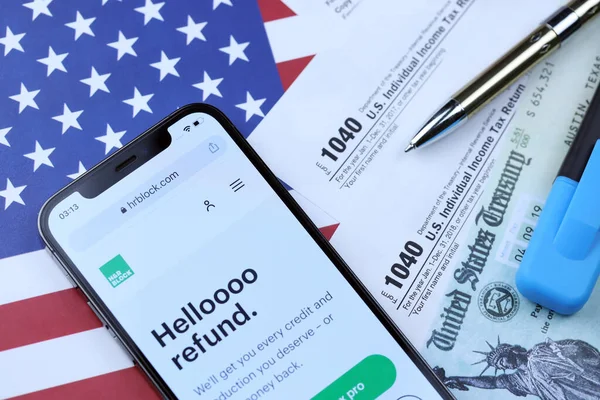 KHARKOV, UKRAINE - 5 Mart 2021: HR Bloğu web sitesi iPhone 12 profesyonel ekranda 1040 ve W-2 kağıt vergi formları ABD bayrağında