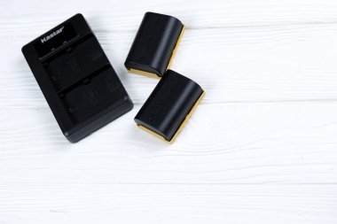 KHARKOV, UKRAINE - 14 Mart 2021: Beyaz tahta masa üzerinde modern DSLR fotoğraf makineleri için Kastar lityum iyonu veya li-ion şarj edilebilir piller