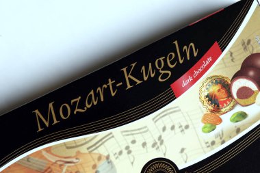 KHARKOV, UKRAINE - 19 Nisan 2021: Henry Lambertz Mozart-Kugeln lüks siyah çikolata şekerlemeleri beyaz ahşap masa üzerindeki kara kutuda