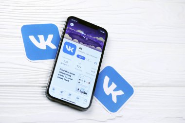 KHARKOV, UKRAINE - 5 Mart 2021: VK simgesi ve uygulaması iPhone 12 'den beyaz ahşap masadaki profesyonel ekranda