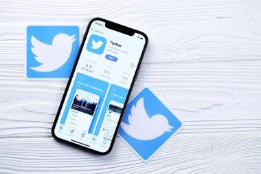 KHARKOV, UKRAINE - 5 Mart 2021: Twitter simgesi ve uygulaması iPhone 12 'den beyaz ahşap masadaki profesyonel ekranda