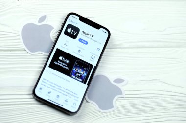 KHARKOV, UKRAINE - 5 Mart 2021: Apple TV simgesi ve uygulaması iPhone 12 'den beyaz ahşap masadaki profesyonel ekranda