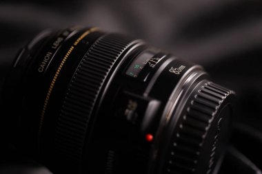 KHARKOV, UKRAINE - 21 Ocak 2021: Siyah kumaş zemin üzerinde Canon EF 85mm 1.8 lens. Canon marka ürününün ayrıntılı fotoğrafı