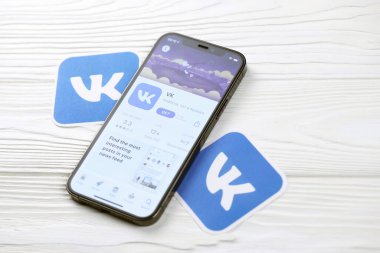 KHARKOV, UKRAINE - 5 Mart 2021: VK simgesi ve uygulaması iPhone 12 'den beyaz ahşap masadaki profesyonel ekranda