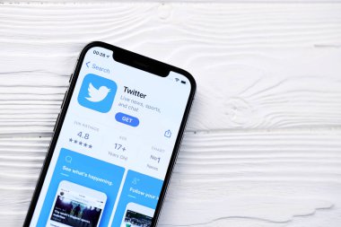 KHARKOV, UKRAINE - 5 Mart 2021: Twitter simgesi ve uygulaması iPhone 12 'den beyaz ahşap masadaki profesyonel ekranda