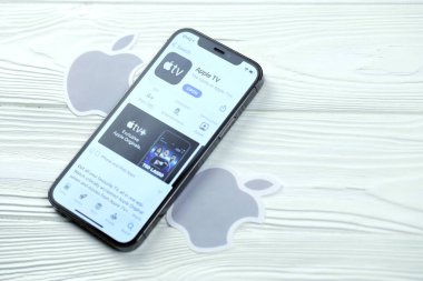 KHARKOV, UKRAINE - 5 Mart 2021: Apple TV simgesi ve uygulaması iPhone 12 'den beyaz ahşap masadaki profesyonel ekranda