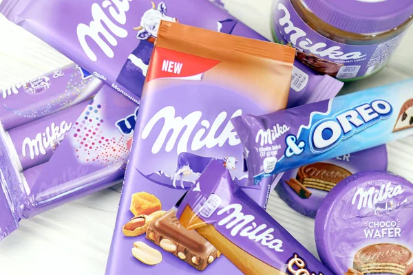 KHARKOV, UKRAINE - 2 Temmuz 2021: Beyaz ahşap masa üzerinde klasik leylak rengi ambalaj tasarımlı Milka çikolata ürünleri