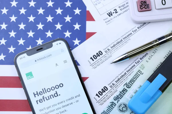 KHARKOV, UKRAINE - 5 Mart 2021: HR Bloğu web sitesi iPhone 12 profesyonel ekranda 1040 ve W-2 kağıt vergi formları ABD bayrağında