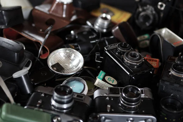 KHARKOV, UKRAINE - 27 Nisan 2021: Fotoğraf makineleri ve fotoğrafçı karanlık odasındaki siyah ahşap masada eski bir fotoğraf makinesi. Sovyetler Birliği zamanından fotoğraf malzemeleri.