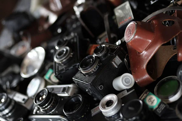 KHARKOV, UKRAINE - 27 Nisan 2021: Fotoğraf makineleri ve fotoğrafçı karanlık odasındaki siyah ahşap masada eski bir fotoğraf makinesi. Sovyetler Birliği zamanından fotoğraf malzemeleri.