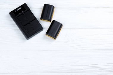 KHARKOV, UKRAINE - 14 Mart 2021: Beyaz tahta masa üzerinde modern DSLR fotoğraf makineleri için Kastar lityum iyonu veya li-ion şarj edilebilir piller
