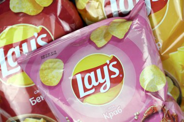KHARKOV, UKRAINE - 3 HAZİRAN 2021: Ahşap zemin üzerinde lay 's patates cipsi çeşitli aromalı. Lay 's 1965' ten beri PepsiCo tarafından Frito-Lay 'e ait.