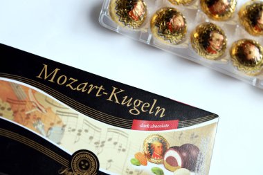 KHARKOV, UKRAINE - 19 Nisan 2021: Henry Lambertz Mozart-Kugeln lüks siyah çikolata şekerlemeleri beyaz ahşap masa üzerindeki kara kutuda