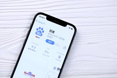 KHARKOV, UKRAINE - 5 Mart 2021: Baidu simgesi ve uygulaması iPhone 12 'de beyaz ahşap masadaki profesyonel ekranda