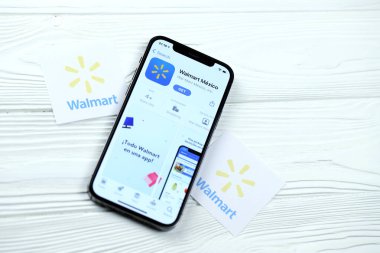 KHARKOV, UKRAINE - 5 Mart 2021: Walmart simgesi ve uygulaması iPhone 12 'den beyaz ahşap masadaki profesyonel ekranda