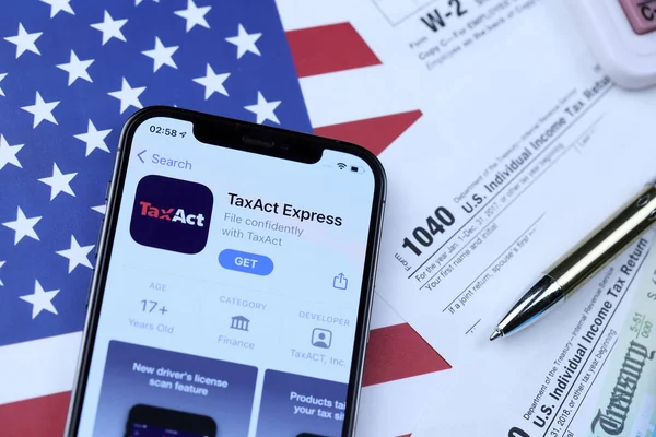 KHARKOV, UKRAINE - 5 Mart 2021: Vergilendirme ekspres uygulaması iPhone 12 profesyonel ekranda 1040 ve W-2 ABD bayrağında kağıt vergisi formları