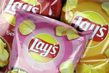 KHARKOV, UKRAINE - 3 HAZİRAN 2021: Ahşap zemin üzerinde lay 's patates cipsi çeşitli aromalı. Lay 's 1965' ten beri PepsiCo tarafından Frito-Lay 'e ait.