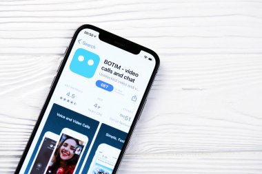 KHARKOV, UKRAINE - 5 Mart 2021: Botim kurye simgesi ve uygulaması iPhone 12 'den beyaz ahşap masadaki profesyonel ekranda