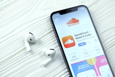 KHARKOV, UKRAINE - 5 Mart 2021: Soundcloud simgesi ve uygulaması iPhone 12 profesyonel ekranda beyaz ahşap masadaki uçak podları profosyoneli