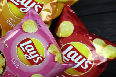 KHARKOV, UKRAINE - 3 HAZİRAN 2021: Ahşap zemin üzerinde lay 's patates cipsi çeşitli aromalı. Lay 's 1965' ten beri PepsiCo tarafından Frito-Lay 'e ait.