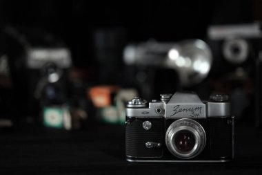 KHARKOV, UKRAINE - 27 Nisan 2021: Zenit 3 m fotoğraf makinesi ve fotoğrafçı karanlık odasındaki siyah ahşap masada eski bir fotoğraf makinesi. Sovyetler Birliği zamanından fotoğraf malzemeleri.