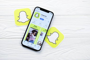 KHARKOV, UKRAINE - 5 Mart 2021: Snapchat simgesi ve uygulaması iPhone 12 'den beyaz ahşap masadaki profesyonel ekranda