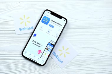 KHARKOV, UKRAINE - 5 Mart 2021: Walmart simgesi ve uygulaması iPhone 12 'den beyaz ahşap masadaki profesyonel ekranda