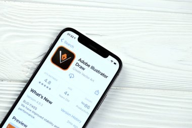 KHARKOV, UKRAINE - 5 Mart 2021: Adobe illüstratör simgesi ve uygulaması iPhone 12 'den beyaz ahşap masadaki profesyonel ekranda