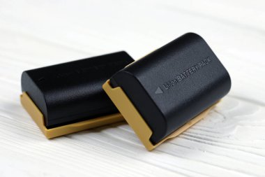 KHARKOV, UKRAINE - 14 Mart 2021: Beyaz tahta masa üzerinde modern DSLR fotoğraf makineleri için Kastar lityum iyonu veya li-ion şarj edilebilir piller